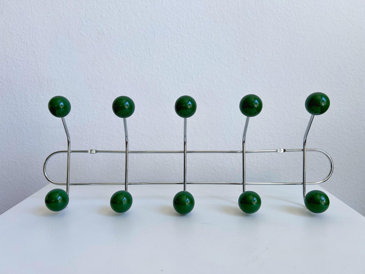 Front view of a silver-colored coat rack with ten dark green ball hooks.