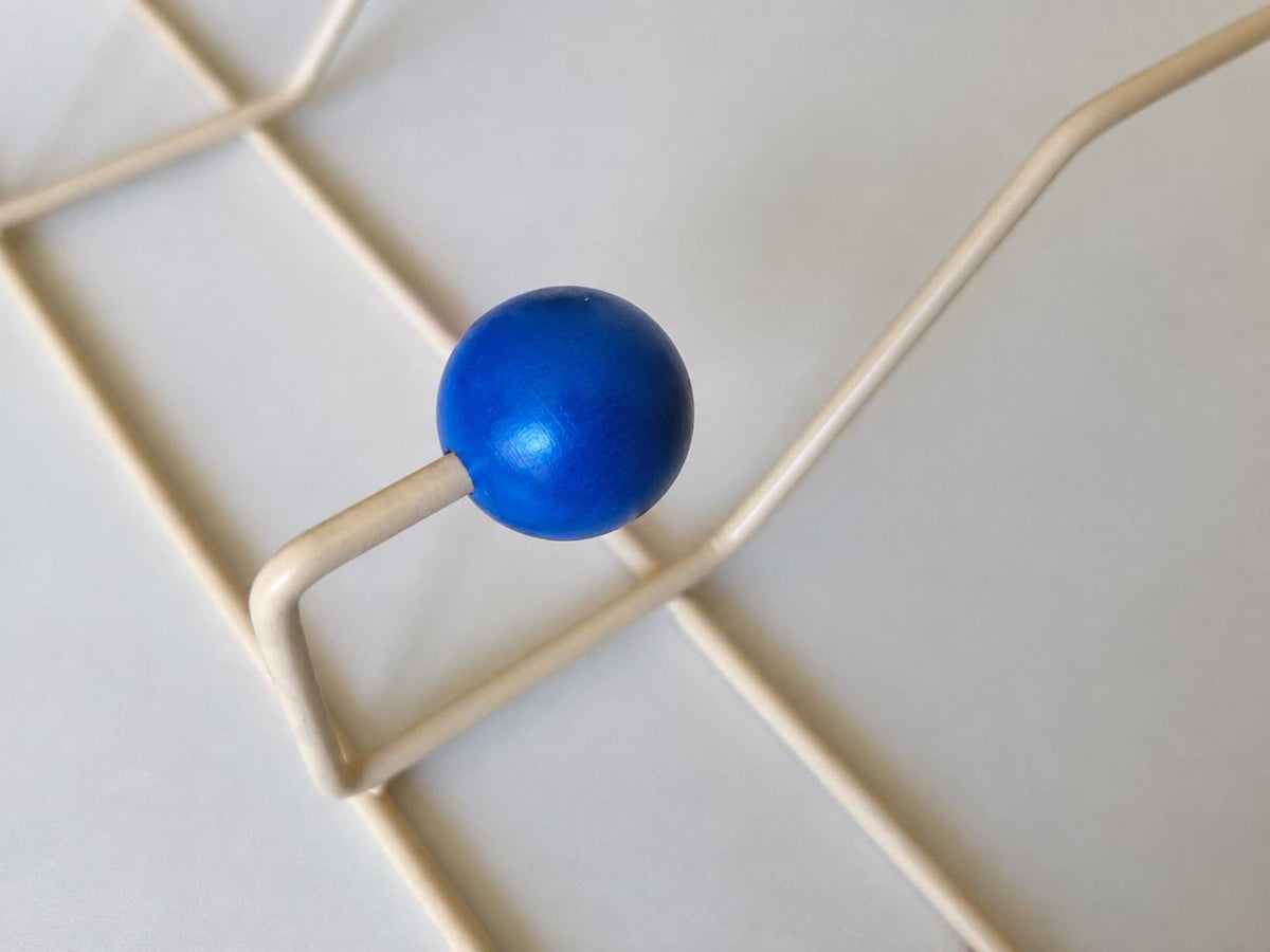 Close-up of a blue ball hook and cream-colored frame.