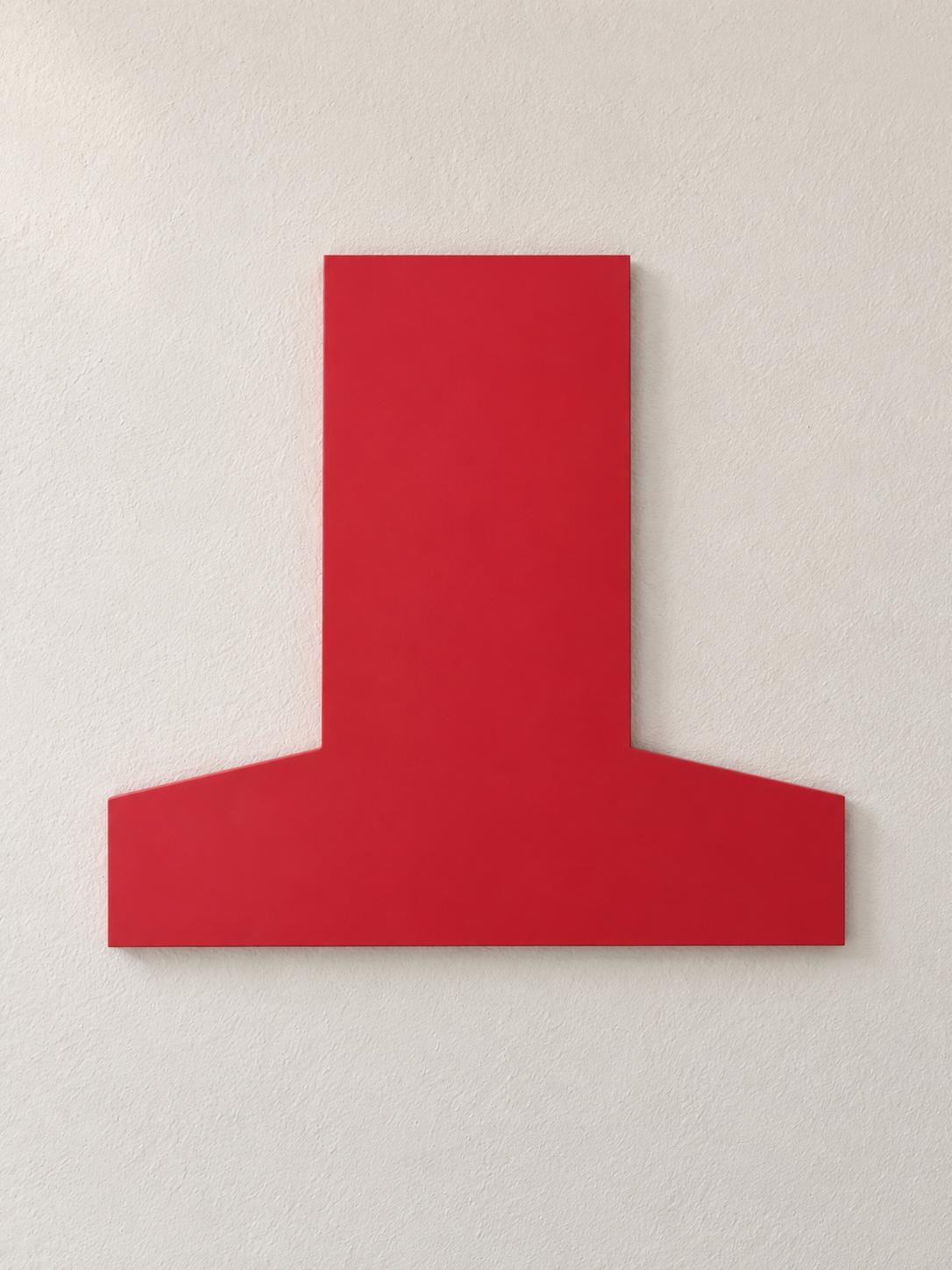 Red inverted-T-shaped wall panel mounted on a cream wall.