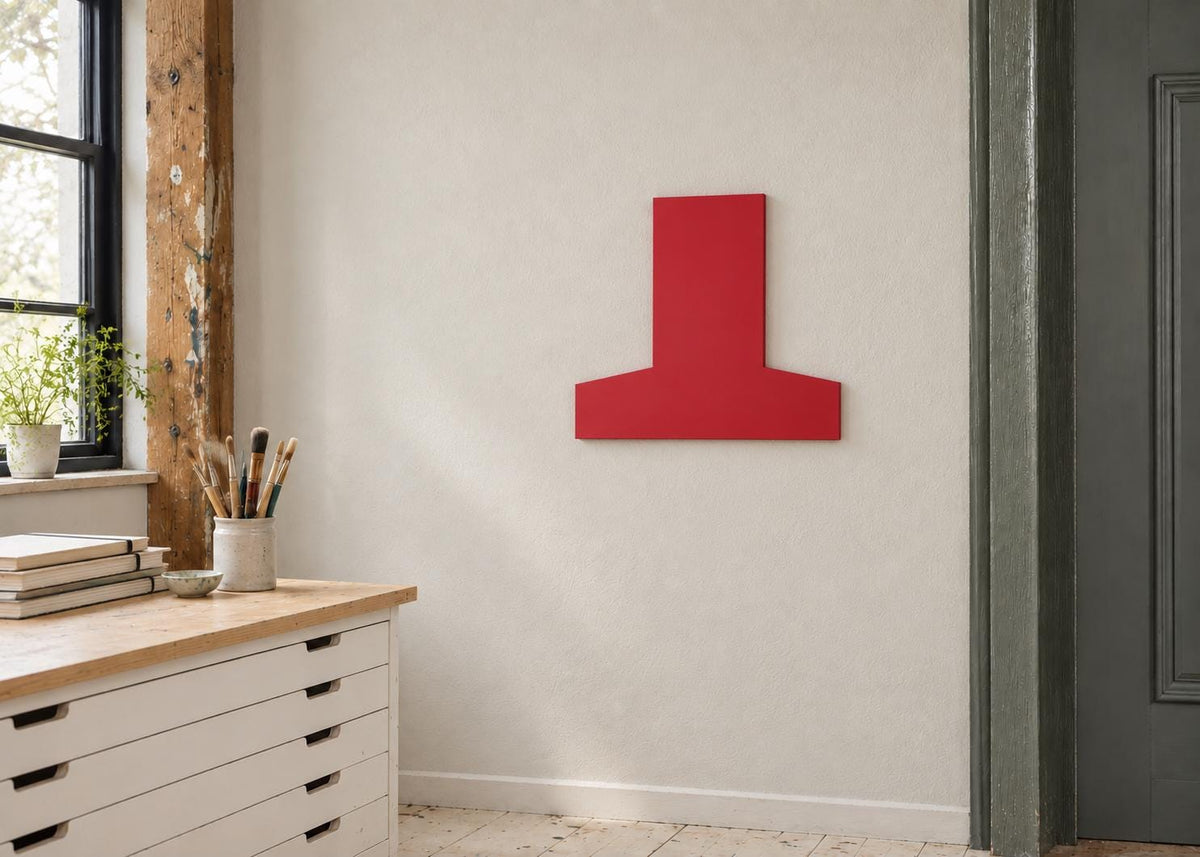 Red inverted-T-shaped wall panel beside a studio window and cabinets.